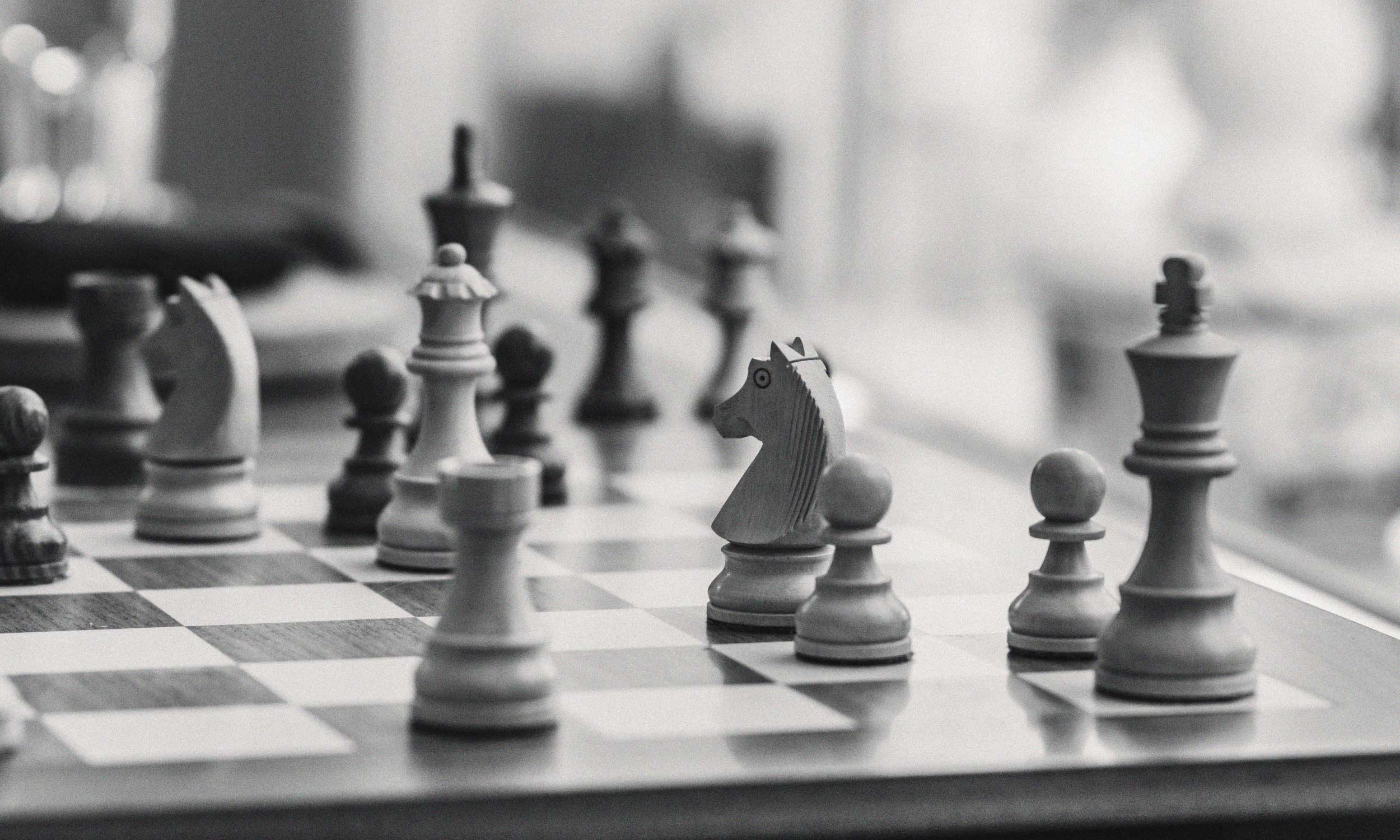 Black-and-white chessboard with opposing pieces, symbolising the impact of entitlement on relationships and conflict.