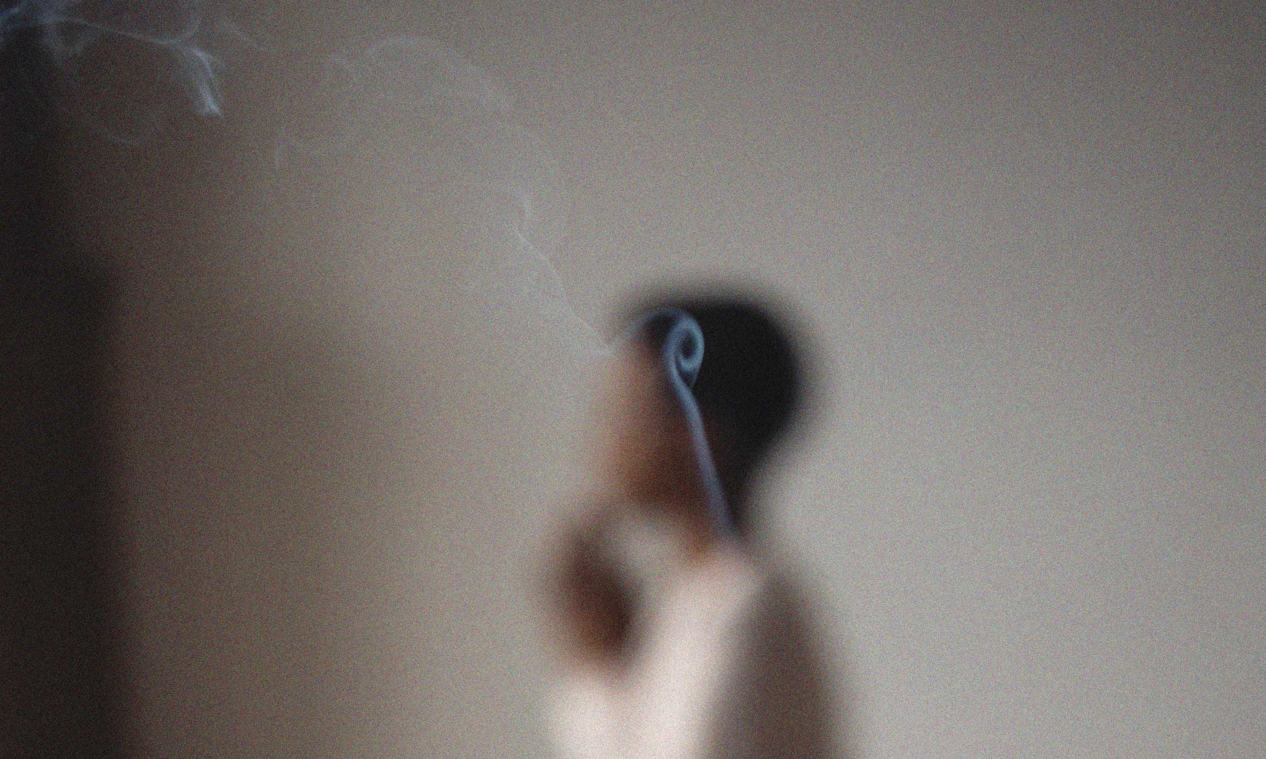 Person meditating or praying with incense smoke swirling nearby, reflecting the practice of living intentionally