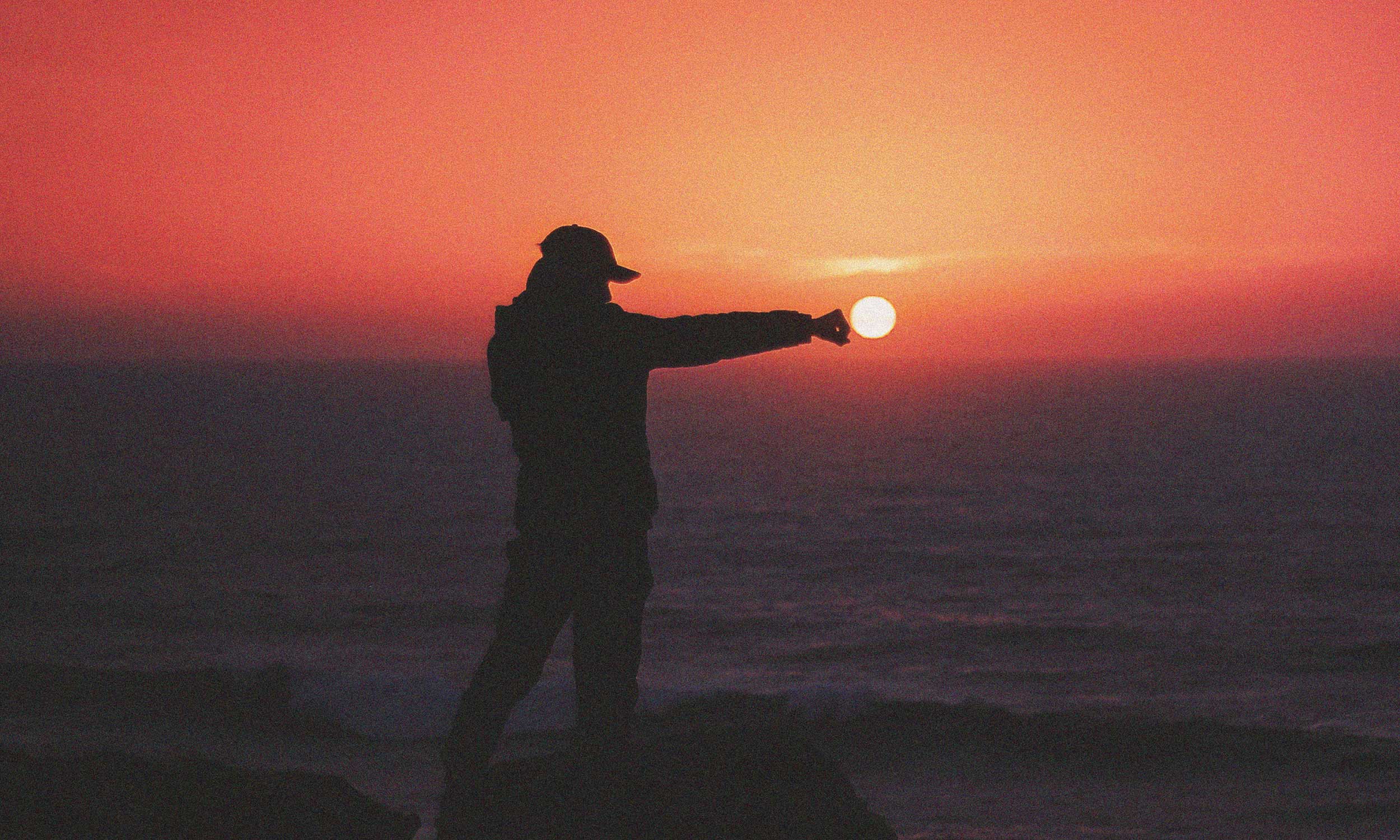 Silhouette of a person reaching toward the setting sun, symbolising personal power, confidence and inner strength